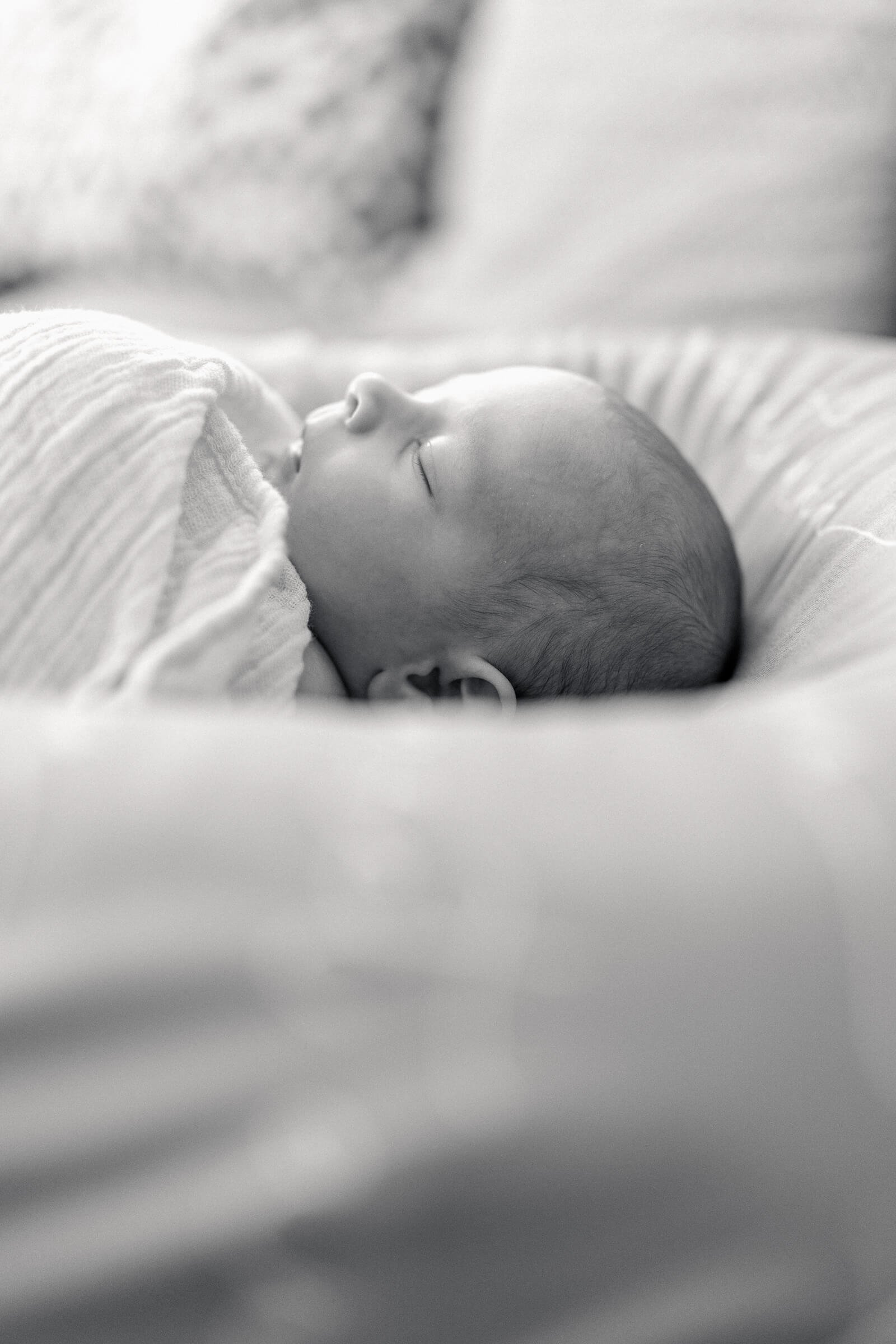 Black and white portrait of sleeping baby on couch