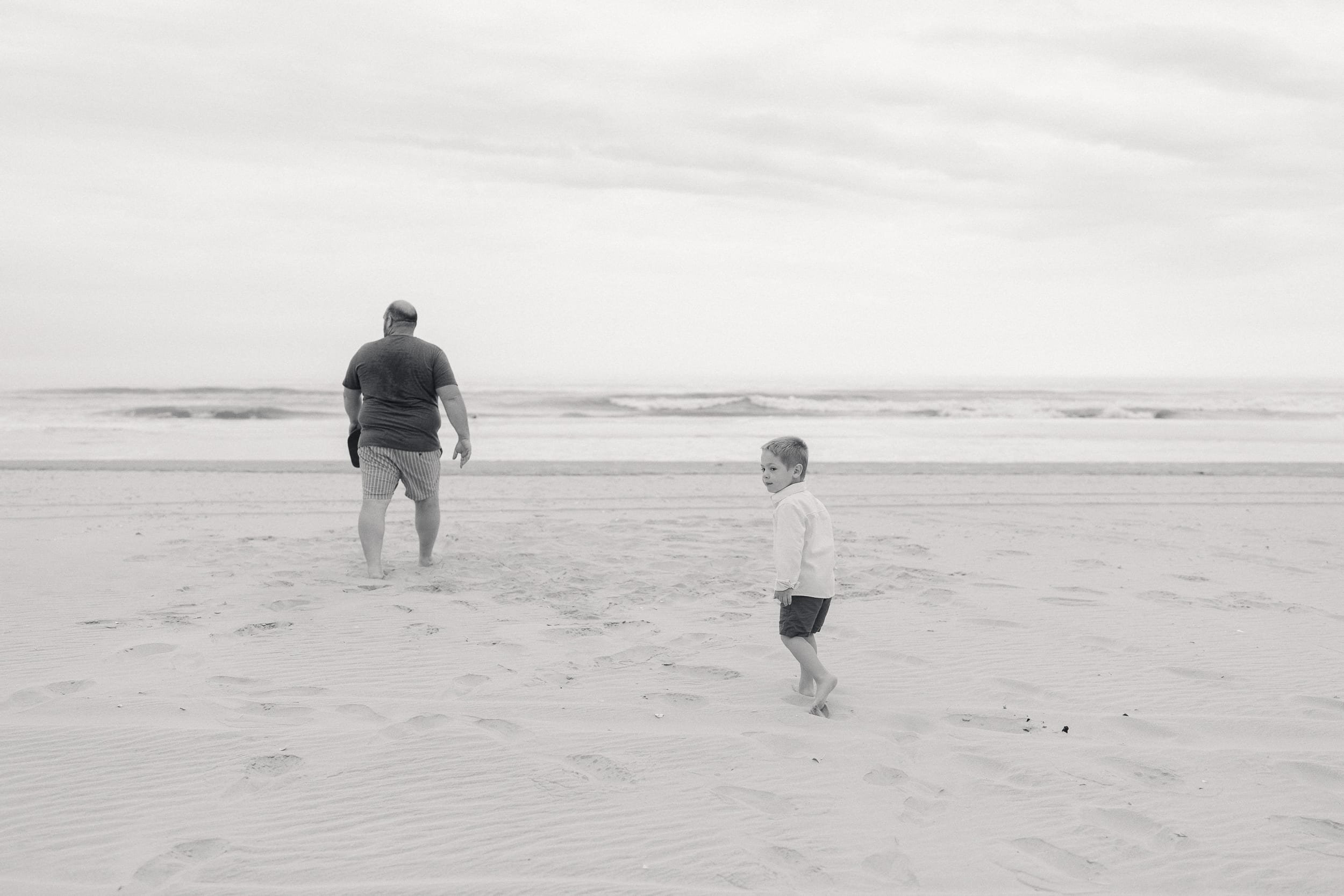 Black and white photo of a father and his young son on the beach in Avalon, NJ.