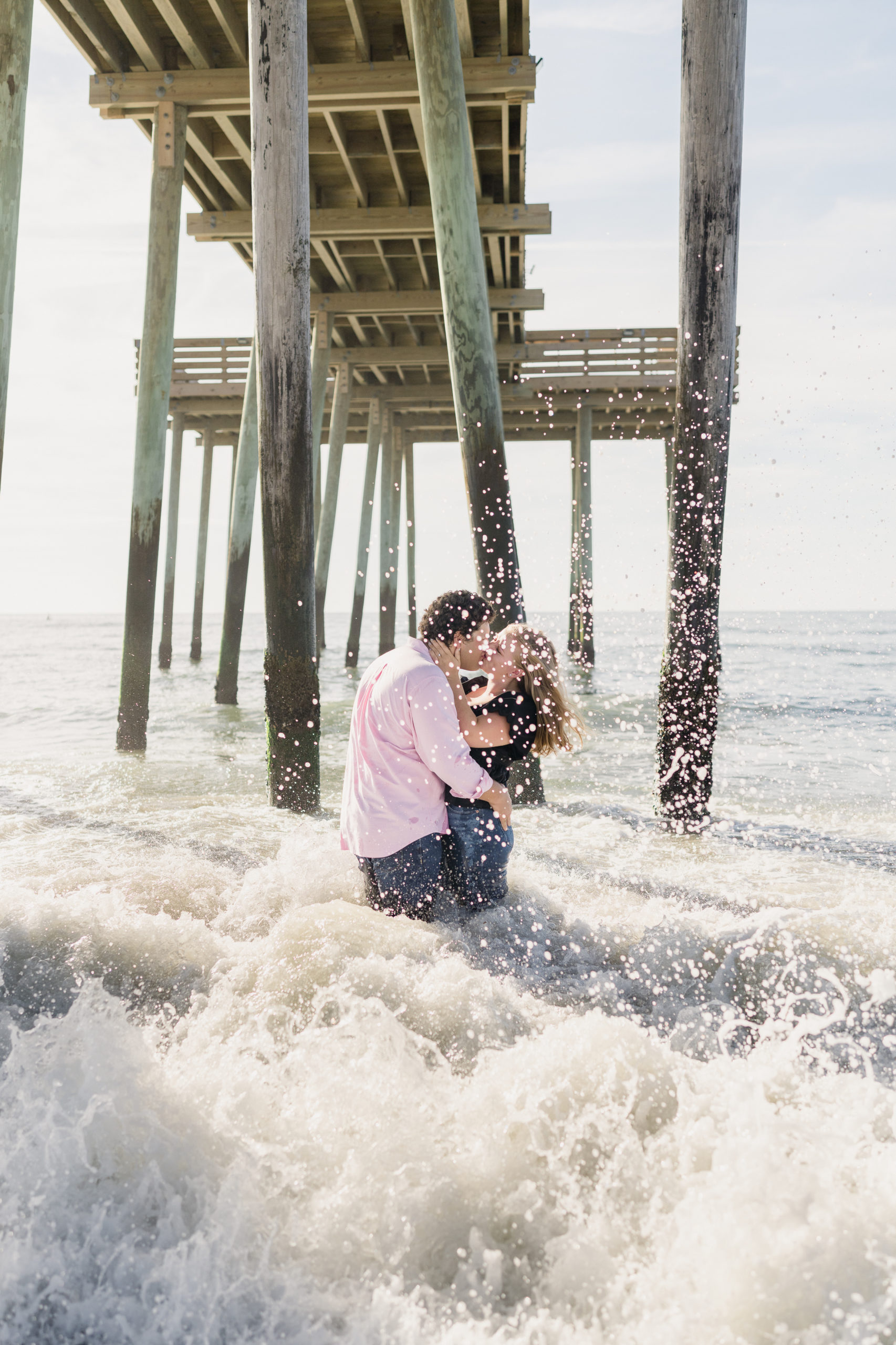 Passionate kiss in the ocean waves by Ocean City NJ Engagement Photographer Courtney Landrum.