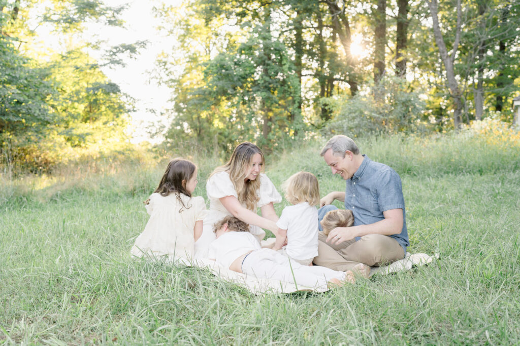 A family of six sits in a meadow during a family photoshoot in Princeton.