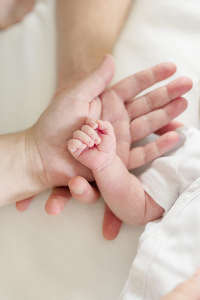 Newborn baby hands with parents hands.