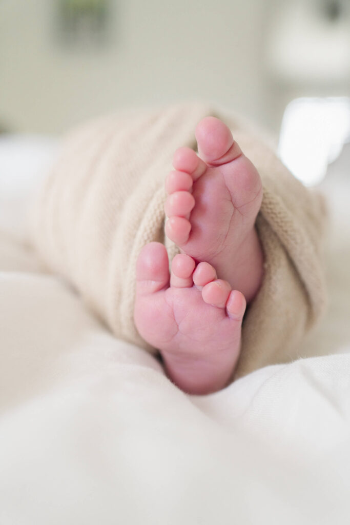 Close-up of newborn baby feet peeking out of a swaddle during a Haddonfield photo session.