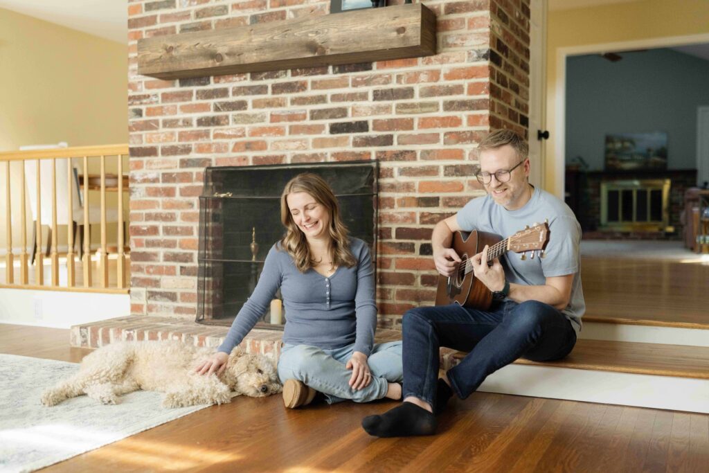 Couple sitting in front of their fireplace with their dog for an in home family session in South Jersey.