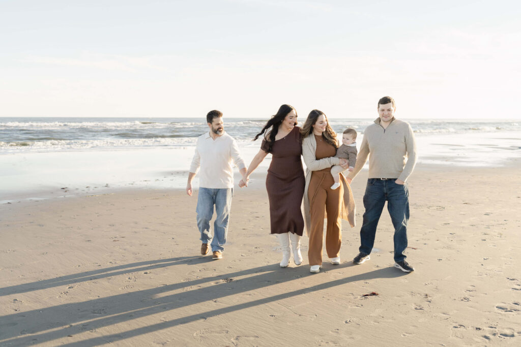 Family walking on Ocean City NJ beach during sunset photo session.