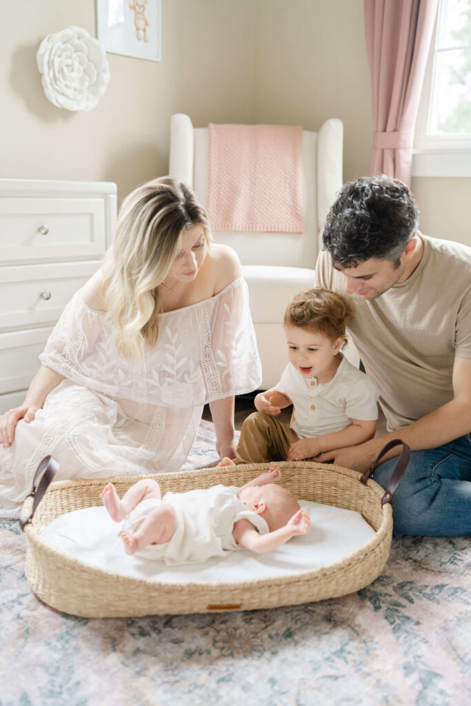An older sibling and his parents look down at their newborn daughter at home in Philadelphia.