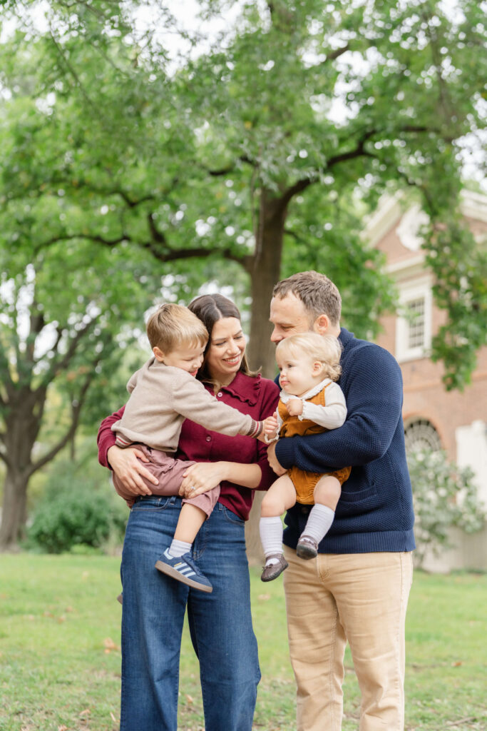 Two parents hug their children in an Old City park.
